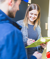 Customer smiling as she signs paperwork