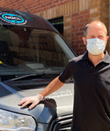 Locksmith wearing mask and glovs in front of NGCL van
