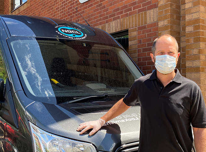 Locksmith wearing mask and glovs in front of NGCL van
